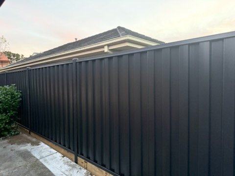 Colorbond boundary fence with level top rail